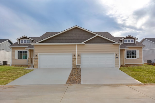 craftsman-style home with central AC unit, a garage, and a front lawn