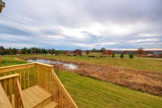 deck with a lawn, a water view, and a rural view