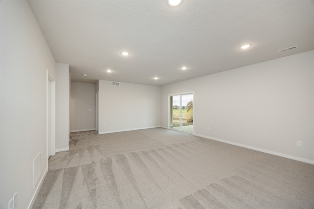 carpeted spare room featuring a textured ceiling