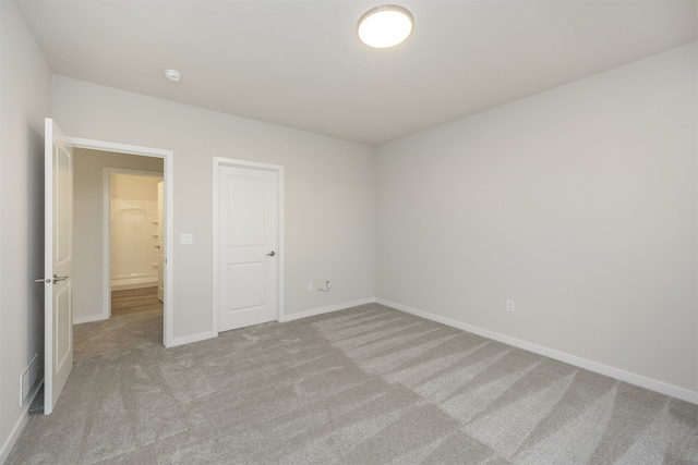 unfurnished bedroom featuring light carpet