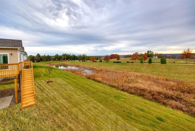 9042 Mockingbird Dr, West Des Moines, IA 50266 - view of grassy yard featuring a deck with water view and stairs
