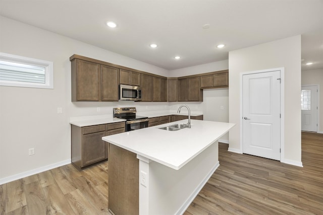 9042 Mockingbird Dr, West Des Moines, IA 50266 - kitchen with stainless steel appliances, a sink, light wood-type flooring, baseboards, and recessed lighting