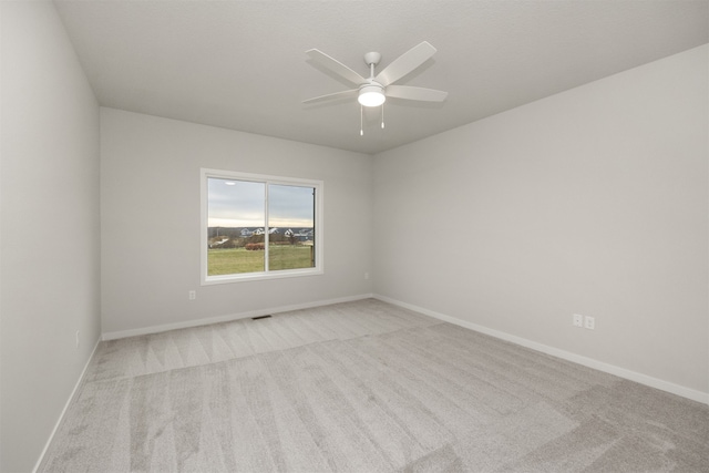 carpeted empty room featuring ceiling fan