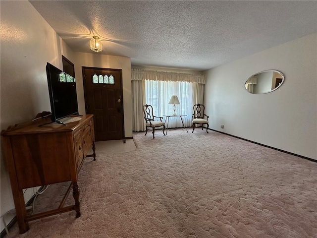 foyer entrance featuring light colored carpet and a textured ceiling