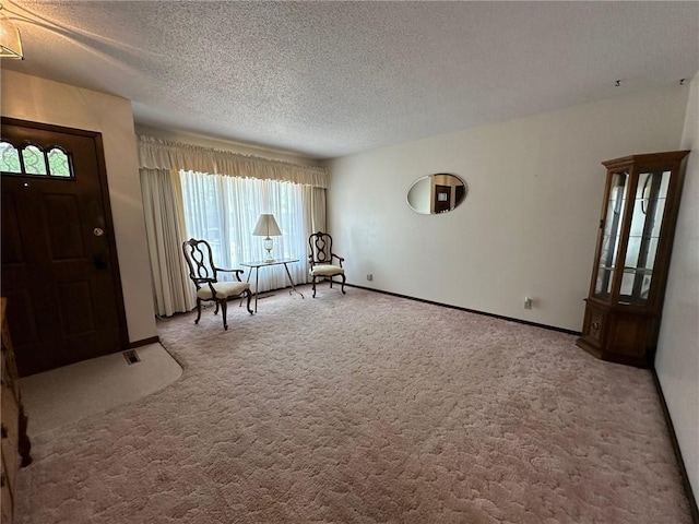 unfurnished room featuring carpet and a textured ceiling