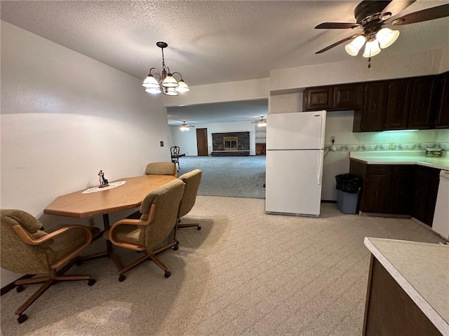 carpeted dining area with a fireplace, a textured ceiling, and a notable chandelier