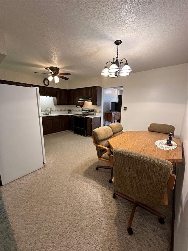 dining area featuring sink, ceiling fan with notable chandelier, light colored carpet, and a textured ceiling