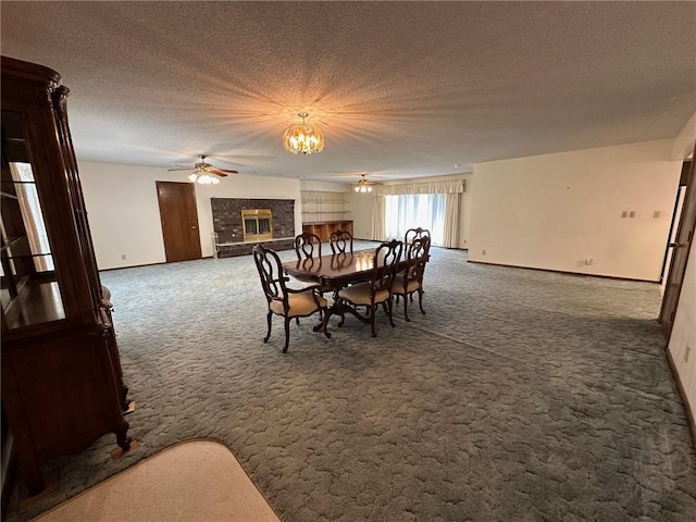 carpeted dining space with ceiling fan with notable chandelier, a textured ceiling, and a brick fireplace