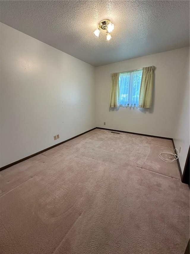 carpeted empty room with a textured ceiling