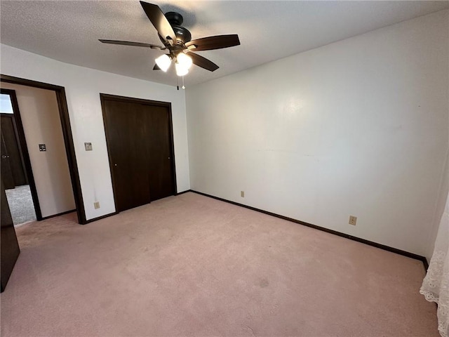 unfurnished bedroom with a closet, light colored carpet, and ceiling fan