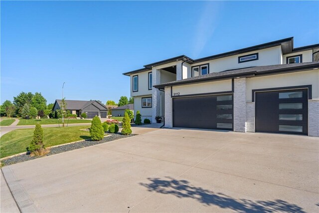 view of front of house featuring a garage and a front lawn