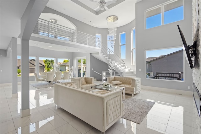 tiled living room featuring ceiling fan and a towering ceiling