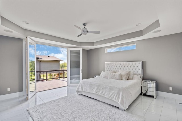 bedroom with a raised ceiling, access to outside, a ceiling fan, and baseboards