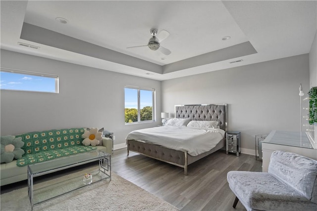 bedroom featuring visible vents, multiple windows, and a tray ceiling