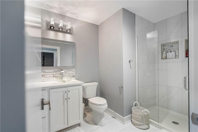 bathroom with baseboards, toilet, a stall shower, tile patterned floors, and vanity