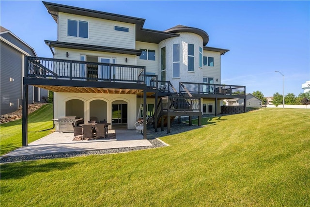 back of property featuring a patio area, a lawn, and a wooden deck