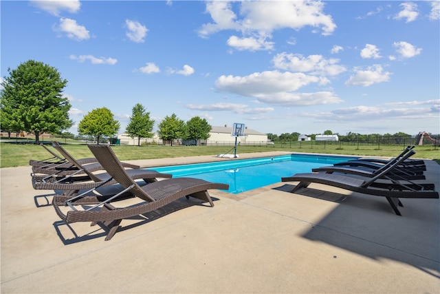 view of pool featuring a patio area and a yard