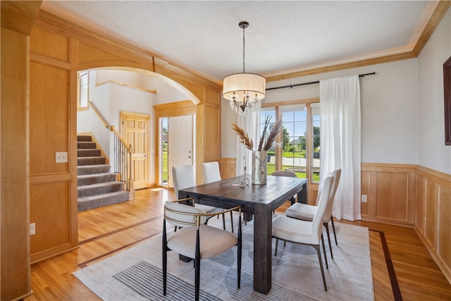 dining room featuring light hardwood / wood-style flooring, a chandelier, and ornamental molding