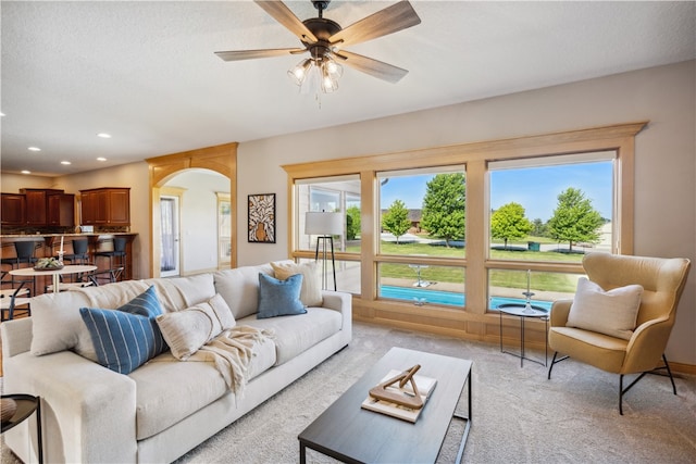 carpeted living room featuring ceiling fan