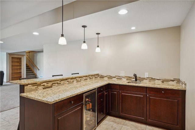 bar with light stone countertops, sink, wine cooler, pendant lighting, and decorative backsplash