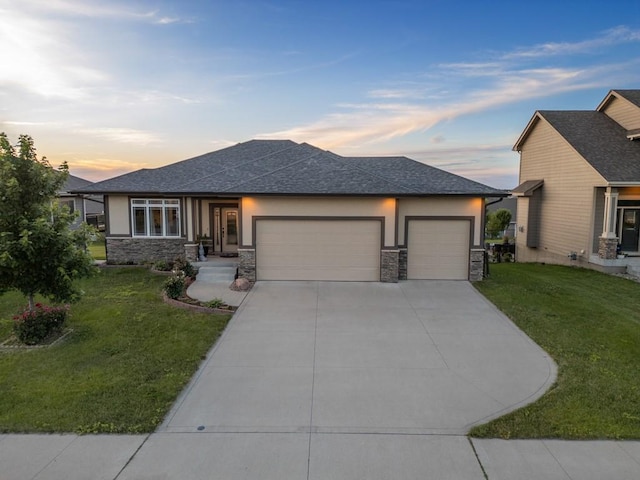 prairie-style home with a yard, stone siding, and stucco siding