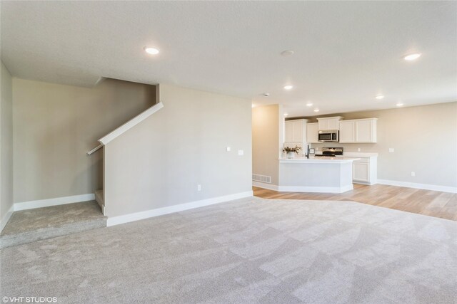 unfurnished living room featuring light carpet