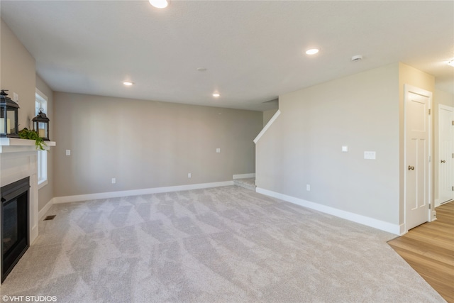 unfurnished living room featuring light carpet