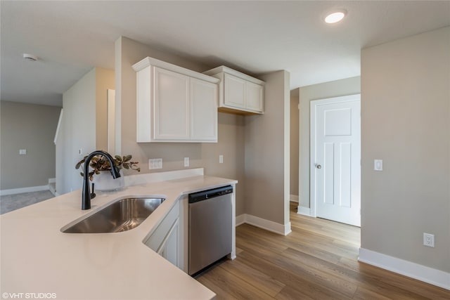 kitchen featuring light wood-type flooring, sink, white cabinetry, and stainless steel dishwasher