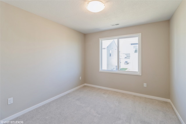 carpeted empty room with a textured ceiling