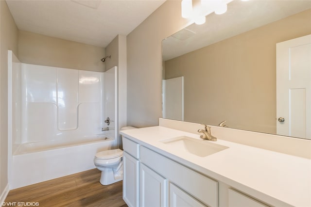 full bathroom with wood-type flooring, vanity, bathtub / shower combination, and toilet