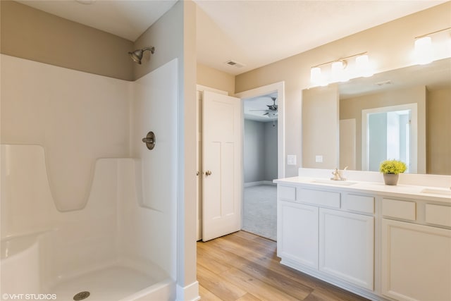 bathroom with a shower, vanity, ceiling fan, and wood-type flooring