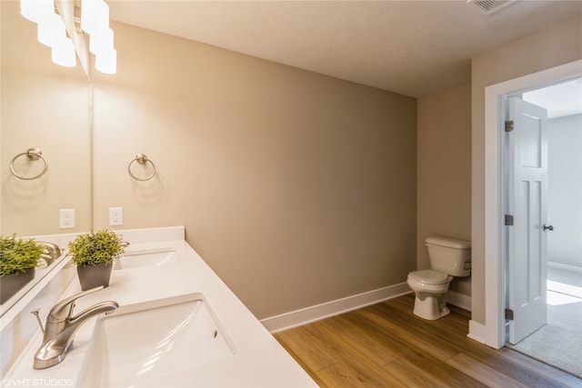 bathroom featuring wood-type flooring, toilet, and sink