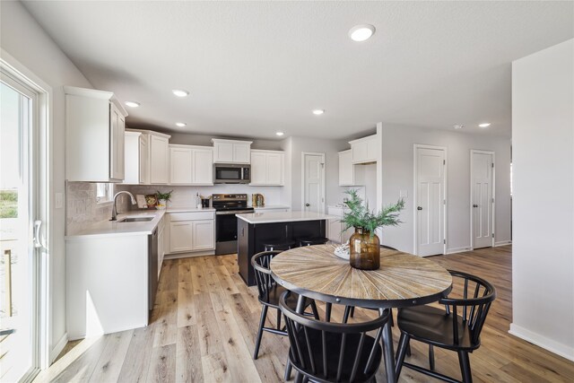 dining area featuring sink and light hardwood / wood-style flooring