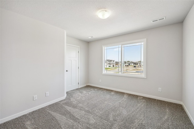 spare room featuring carpet flooring and a textured ceiling