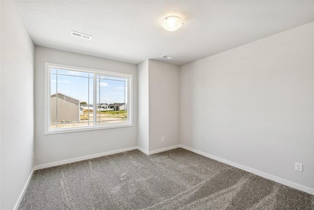 empty room featuring carpet and a textured ceiling