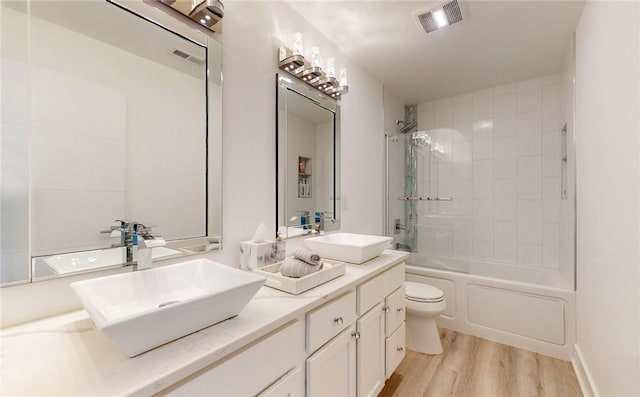 full bathroom with visible vents, a sink, and wood finished floors