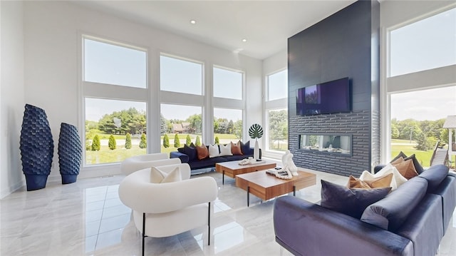 tiled living room featuring a multi sided fireplace and a high ceiling