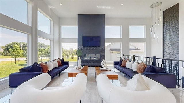 living area featuring recessed lighting, a fireplace, and a high ceiling