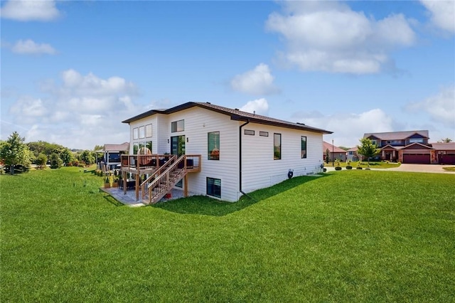 back of house with stairs, a deck, and a lawn