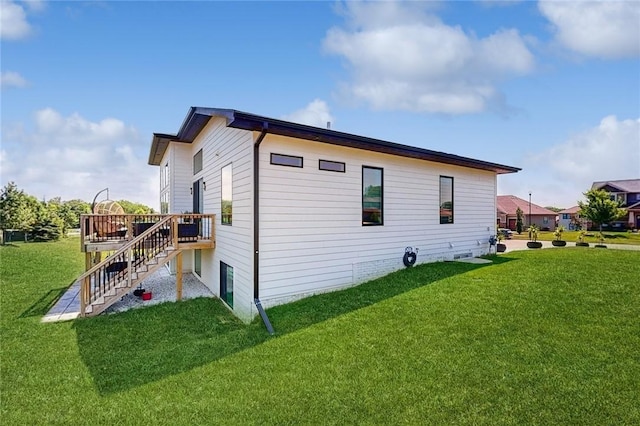 view of home's exterior with stairs, a yard, and a deck