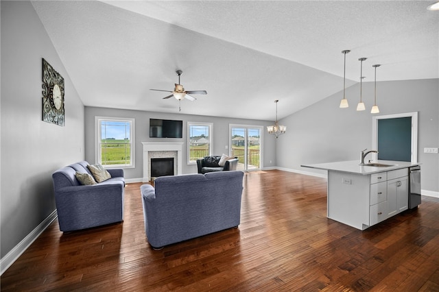 living room featuring vaulted ceiling, a wealth of natural light, dark wood-type flooring, and sink