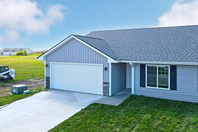 ranch-style home featuring a front lawn and a garage