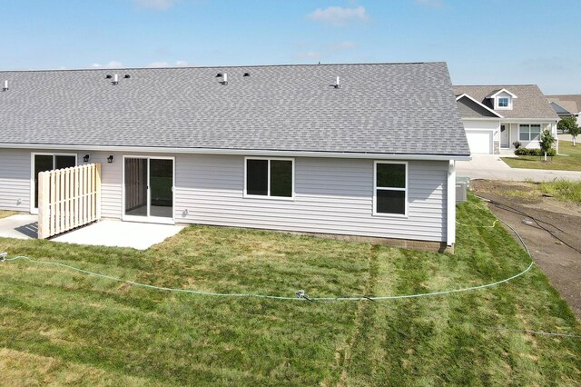 rear view of house with a yard and a garage