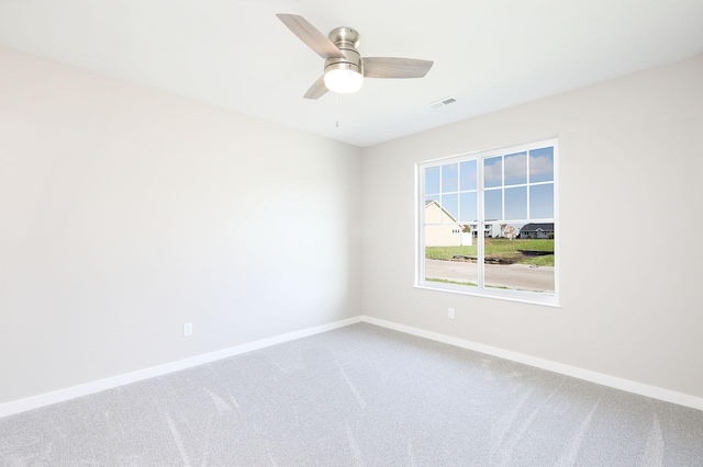 carpeted empty room with visible vents, ceiling fan, and baseboards