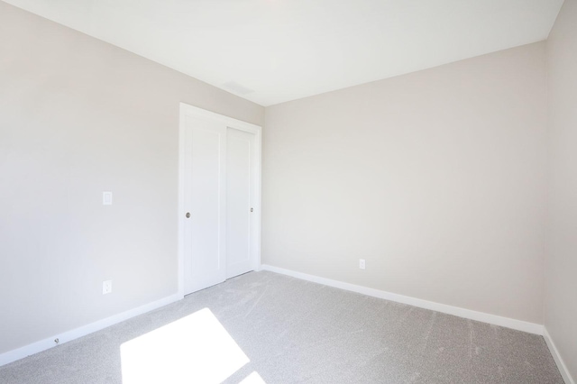 spare room featuring carpet flooring and baseboards