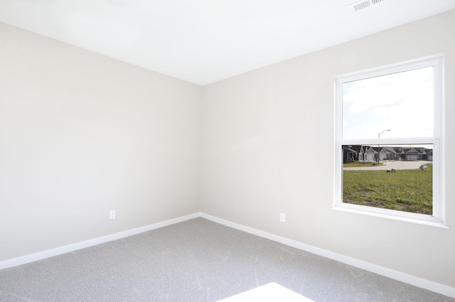 spare room featuring visible vents, baseboards, and carpet flooring