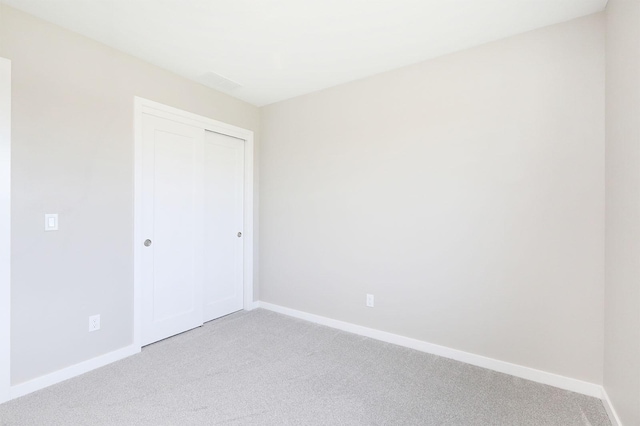 spare room featuring baseboards and light colored carpet