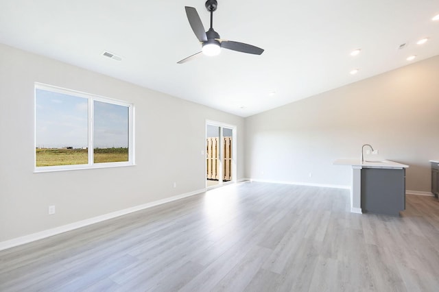 unfurnished living room with light wood finished floors, recessed lighting, visible vents, a ceiling fan, and baseboards