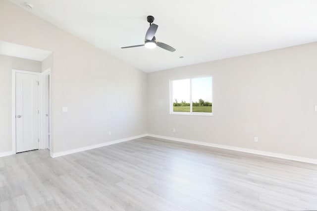 empty room with visible vents, baseboards, a ceiling fan, vaulted ceiling, and light wood-style floors