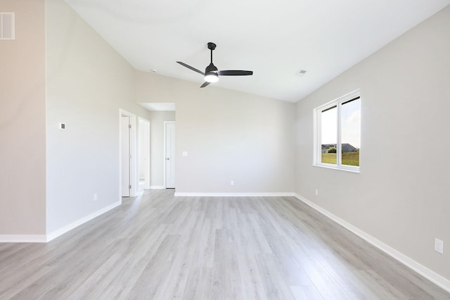 spare room featuring visible vents, baseboards, ceiling fan, vaulted ceiling, and light wood-type flooring